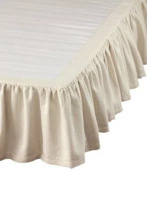 Close-up of a cream-colored bed skirt with pleated details on a white background.